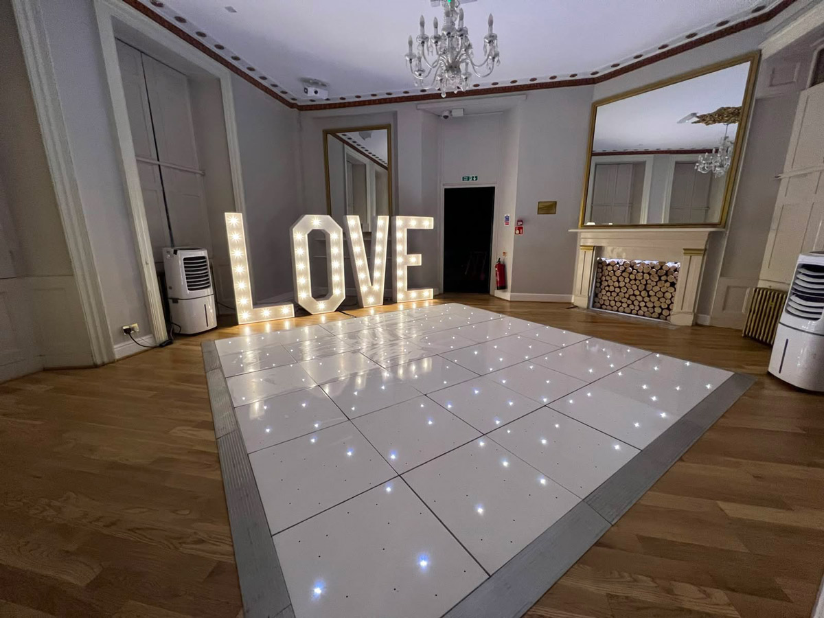 White LED starlit dance floor hire Essex with illuminated LOVE letters at a wedding